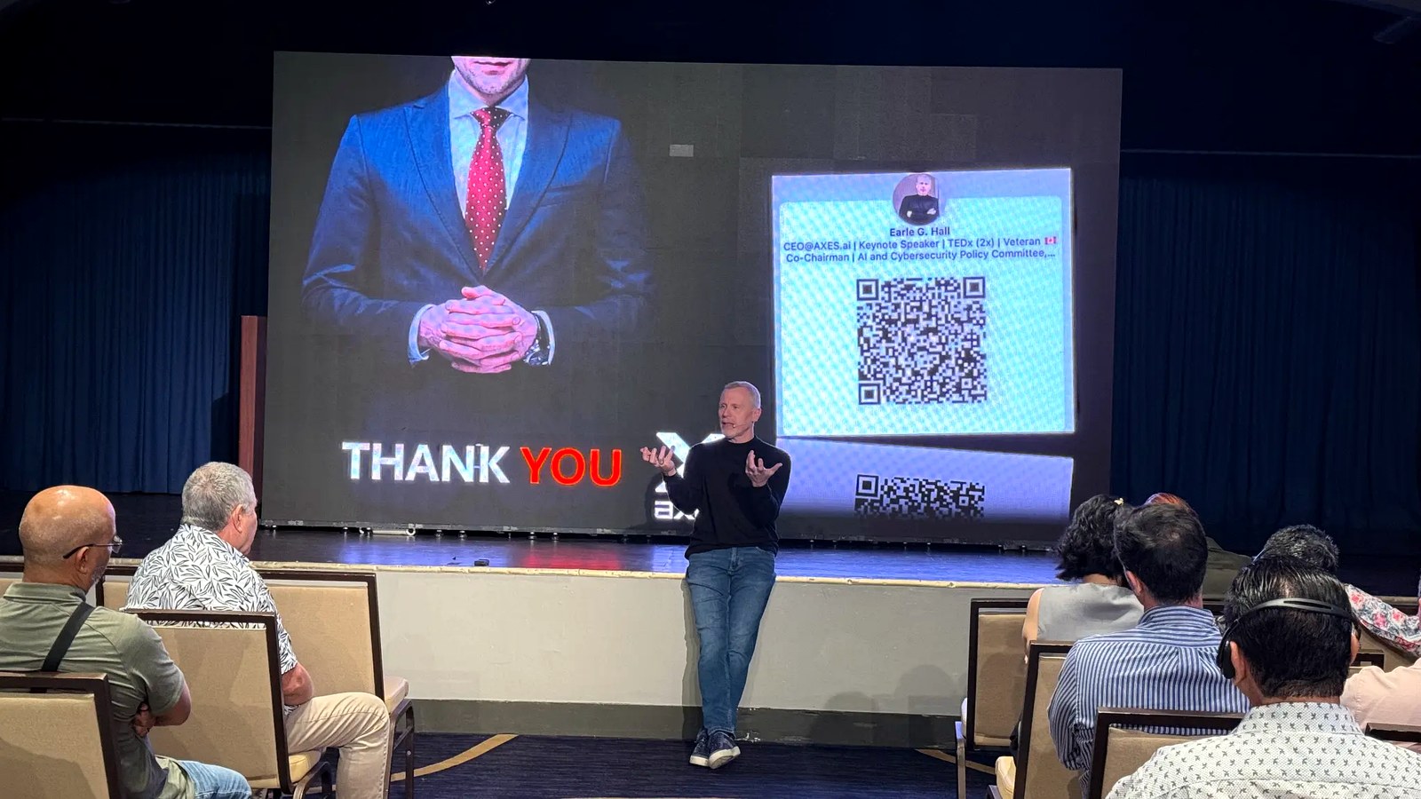CEO Earle G. Hall delivering the closing keynote — "Thank You" on screen, QR code live, audience engaged.